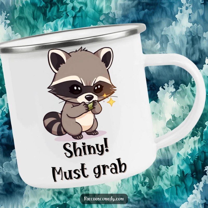 Funny enamel camping mug with a masked raccoon bandit stealing a shiny object, perfect for outdoor humor and rugged adventures.