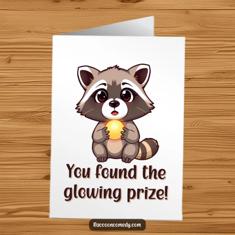 Funny free printable congratulations card featuring a surprised raccoon clutching a tiny, softly glowing orb, discovered in awe.