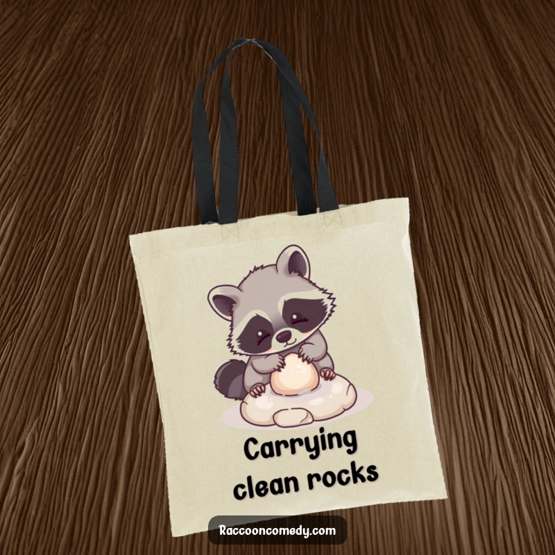 Funny tote bag showcasing a kawaii raccoon character playfully washing a small, round stone, designed for carrying items with charm and whimsy.